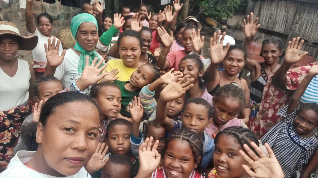 Mothers and twin children of the AMEJ association waving